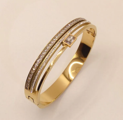 Double row drill buckle bracelet featuring gold titanium steel and sparkling stones, perfect for elegant outfits.