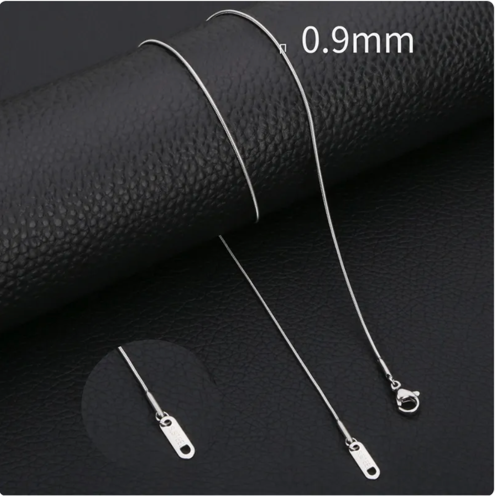 Minimalist stainless steel snake chain necklace displayed on black leather, showcasing its sleek design and 0.9mm thickness.