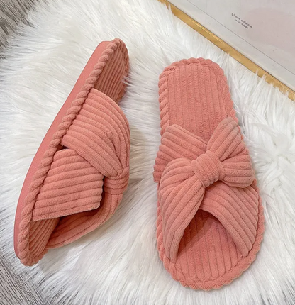 Cute home indoor soft bottom comfortable cotton linen slippers in pink color with knot design on soft surface.