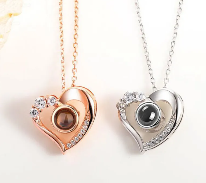 Silver geometric pendant necklace featuring heart designs in rose gold and silver with diamond accents.