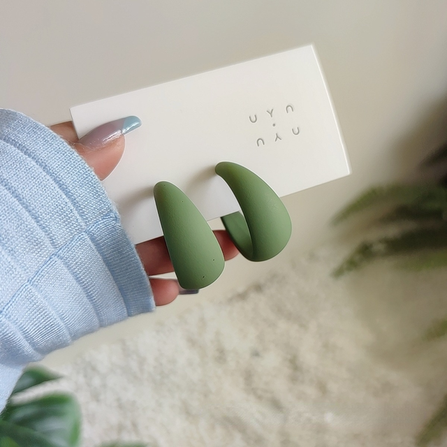 candy color earrings for women in green displayed in hand with packaging