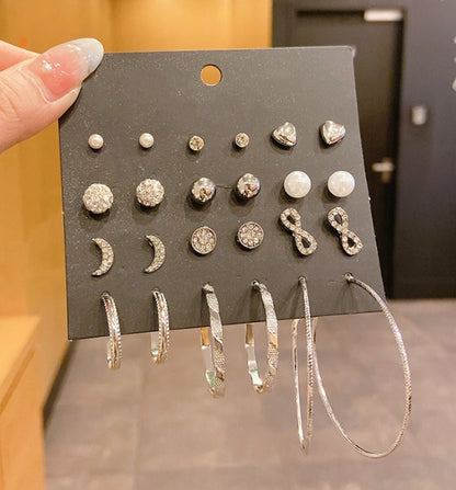 12 pairs of star and moon diamond earrings set displayed on a black card, featuring various designs and styles.