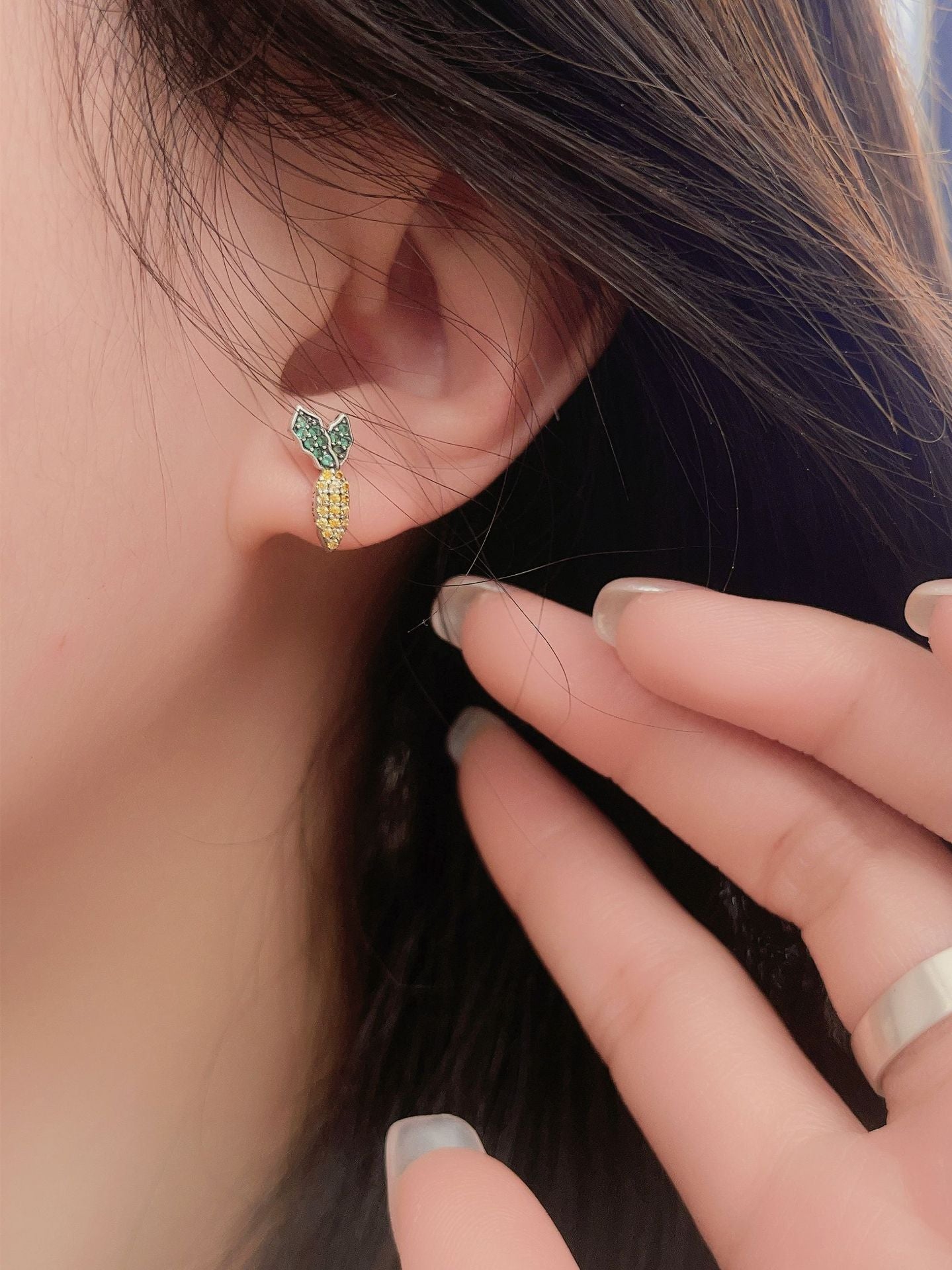 Rabbit and carrot silver earrings worn by a woman, showcasing playful design and intricate craftsmanship.
