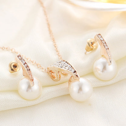 bridal pearl necklace and earrings set featuring diamond-encrusted crystals and freshwater pearls on satin fabric.