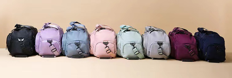 Multi-functional sports bag with wet dry separation in various colors lined up on a table.