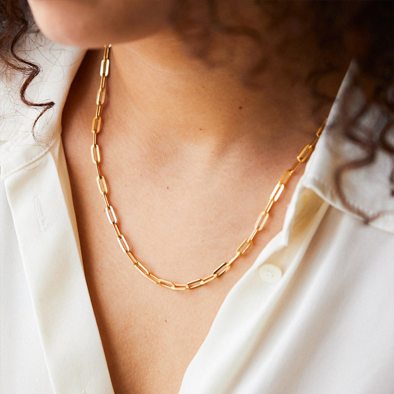 Gold-plated minimalist cross necklace worn by a woman, showcasing its elegant design and shine.