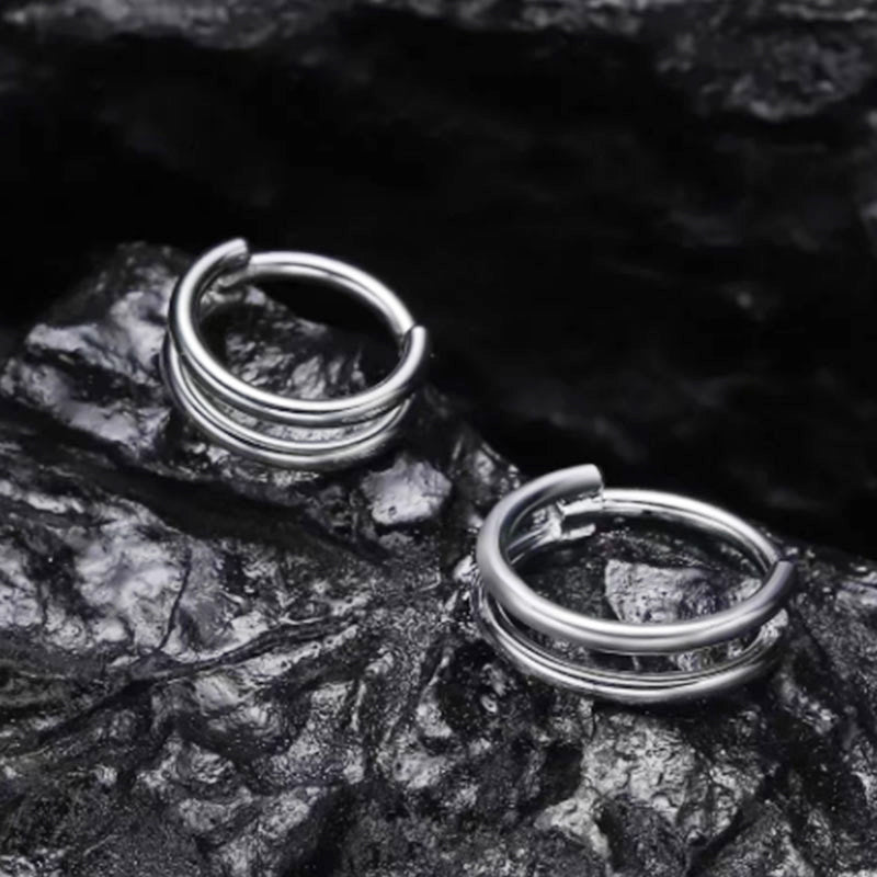 316L stainless steel nose ring and cartilage earring displayed on a textured black surface.