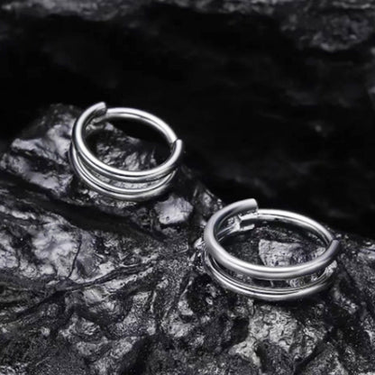 316L stainless steel nose ring and cartilage earring displayed on a textured black surface.