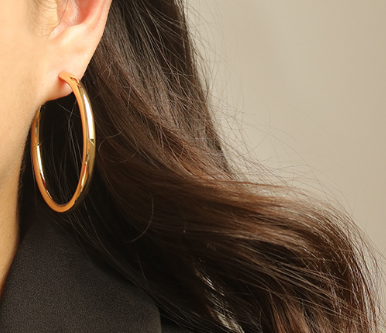 Minimalist brass hoop earrings showcased on a model, enhancing elegance and simplicity.