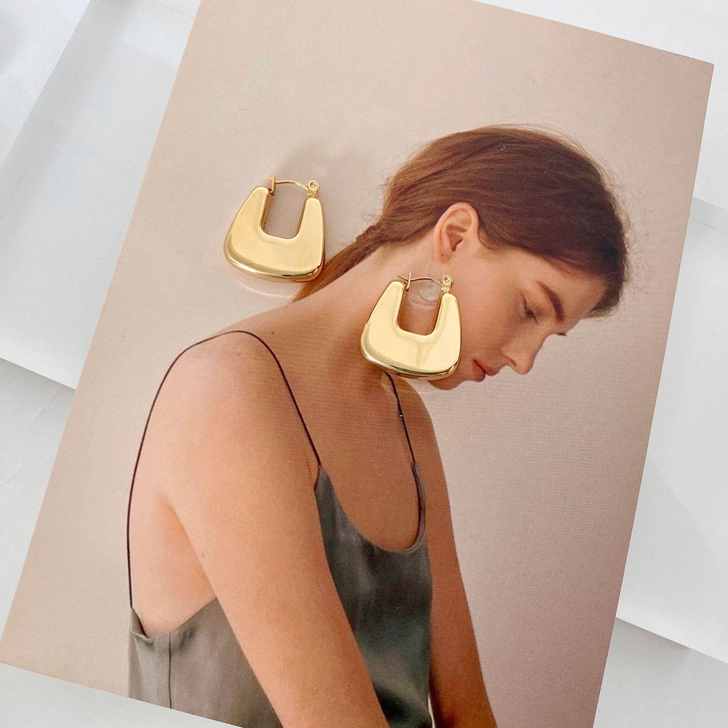 Stainless steel hollow hoop earrings showcased on a model in a stylish setting, emphasizing modern elegance.